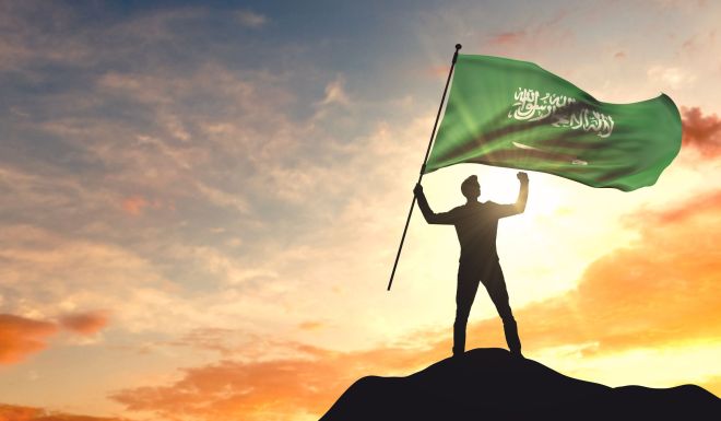Saudi Arabia flag being waved by a man celebrating success at th
